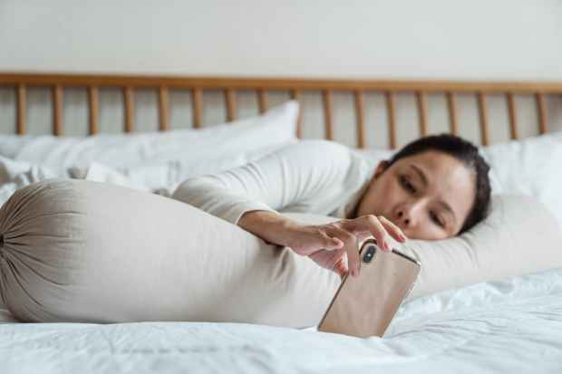 lazy asian woman using smartphone in bed